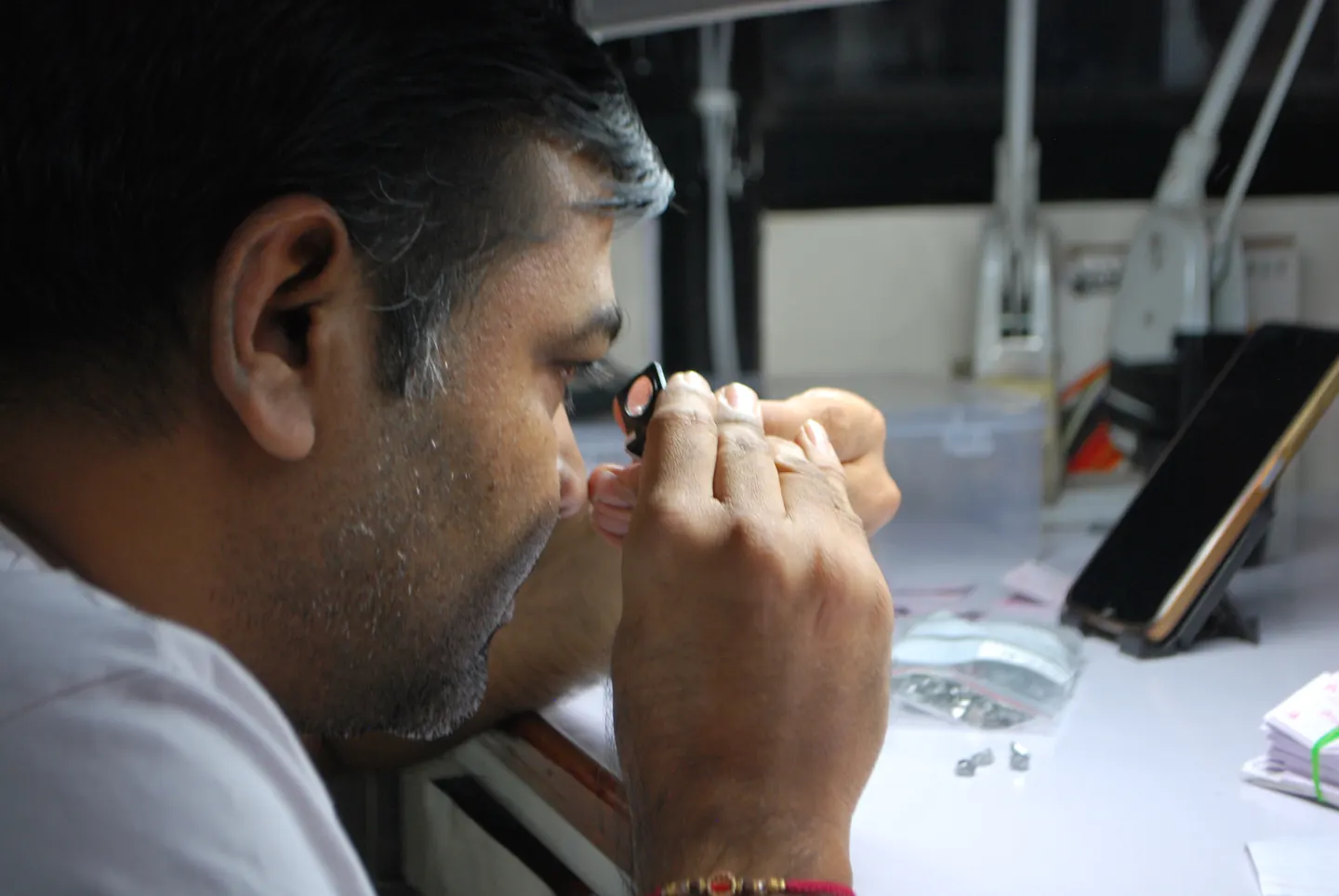 A Sitaram craftsperson inspecting a stone through a loupe