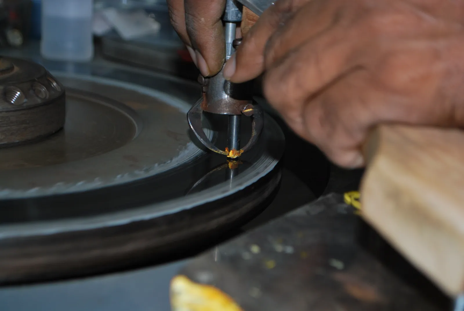 A craftsperson working a diamond at a scaife