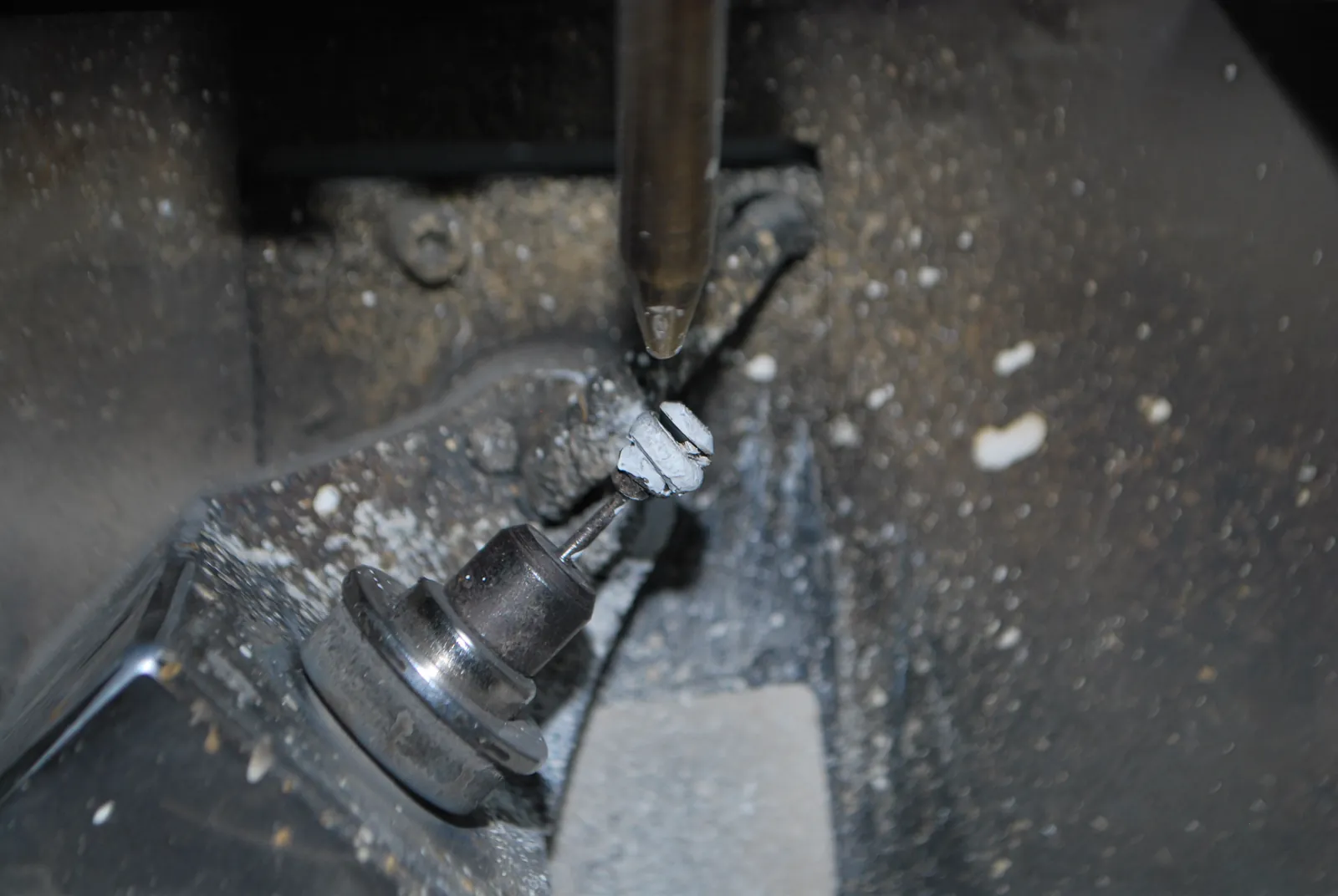Diamond held in a dop beside a shaping wheel